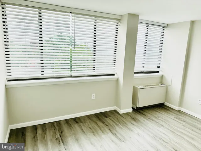 a view of a room with a window and wooden floor