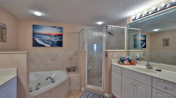 a bathroom with a tub a double vanity sink and a mirror