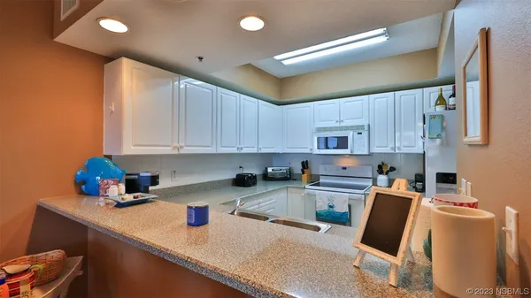 a kitchen with stainless steel appliances granite countertop a sink refrigerator and cabinets