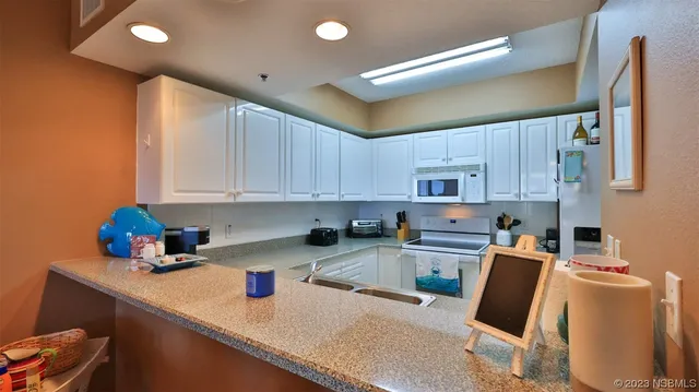 a kitchen with stainless steel appliances granite countertop a sink refrigerator and cabinets