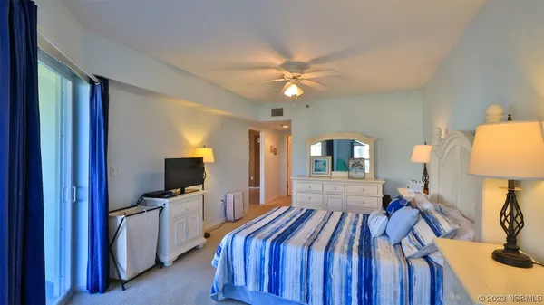 a bedroom with a bed and a flat tv screen on dresser