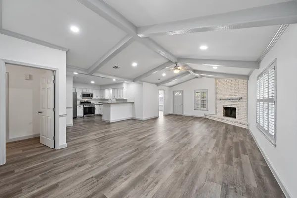 a view of a big room with wooden floors and a kitchen