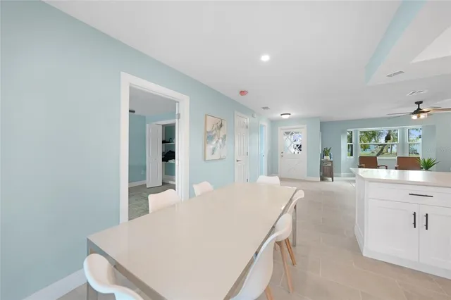 a living room with stainless steel appliances furniture a rug and a kitchen view