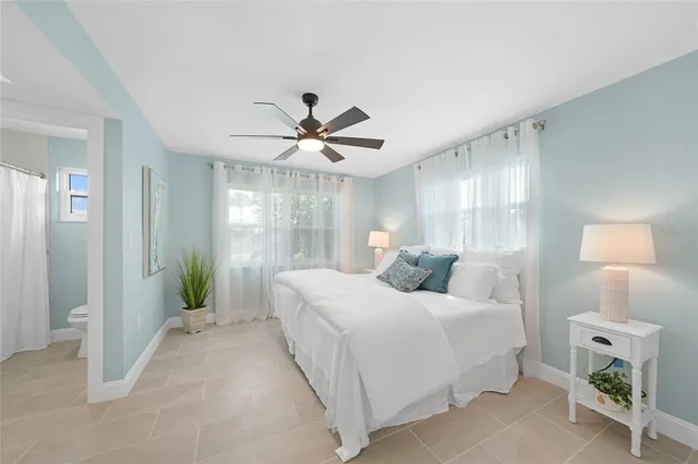 a bedroom with a large bed and a chandelier