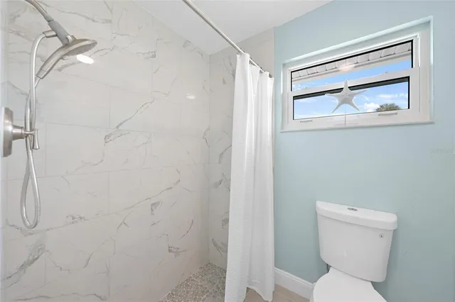 a bathroom with a toilet and a shower