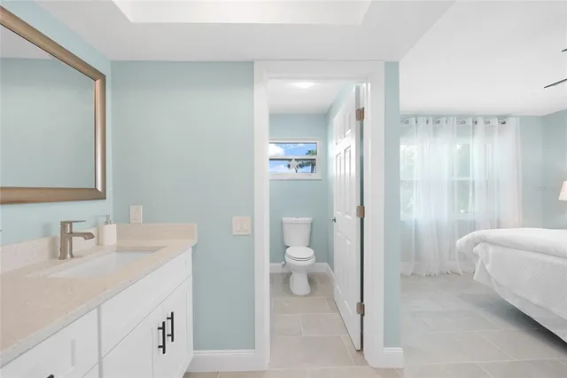 a en suite bathroom with a granite countertop sink and a mirror