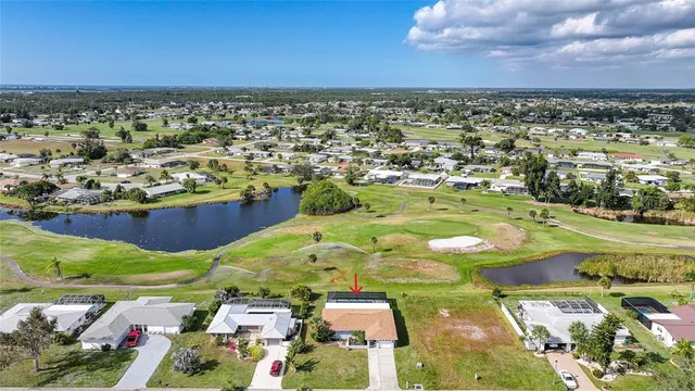 an aerial view of a house with big yard and large trees