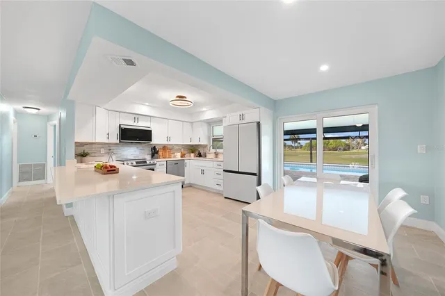 a kitchen with stainless steel appliances kitchen island granite countertop a sink and cabinets