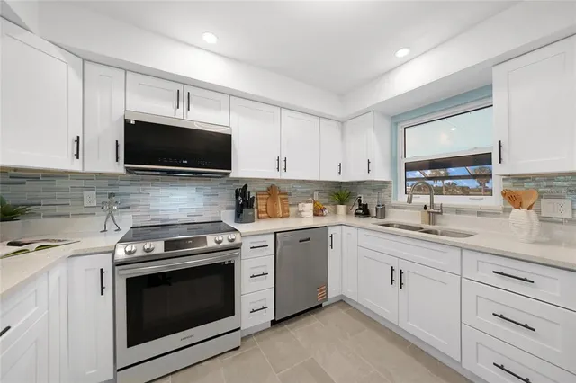 a kitchen with cabinets stainless steel appliances and a window