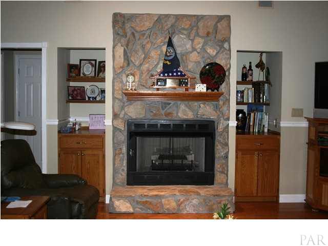 3400 Schifko Road Cantonment, FL 32533 - Photo 6 of 24 Gas log fireplace, built-in bookcases, and cabinets.