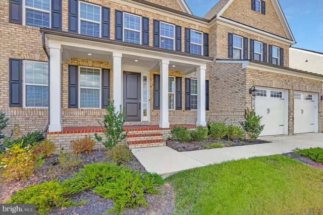 front view of a brick house with a yard