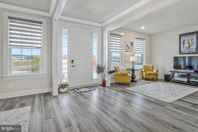 a living room with furniture a flat screen tv and kitchen view