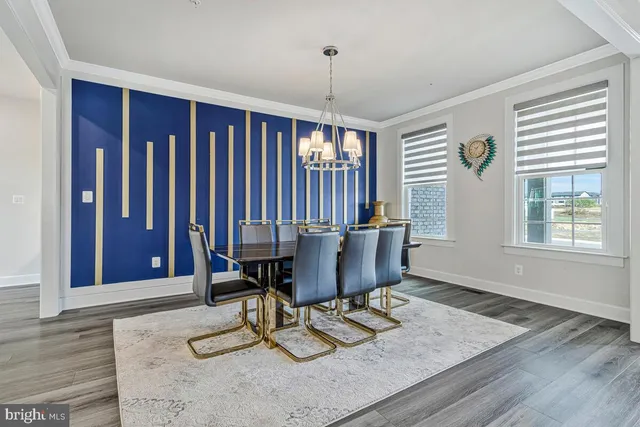 a dining room with wooden floor a chandelier a glass table and chairs
