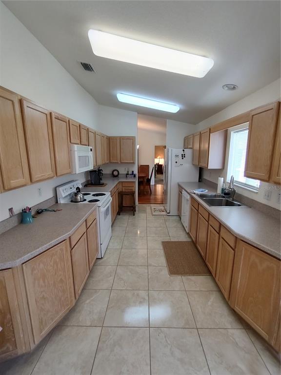 14191 Southwest 115th Terrace Dunnellon, FL 34432 - Photo 13 of 36 a kitchen with stainless steel appliances granite countertop a sink counter space cabinets and a view of living room