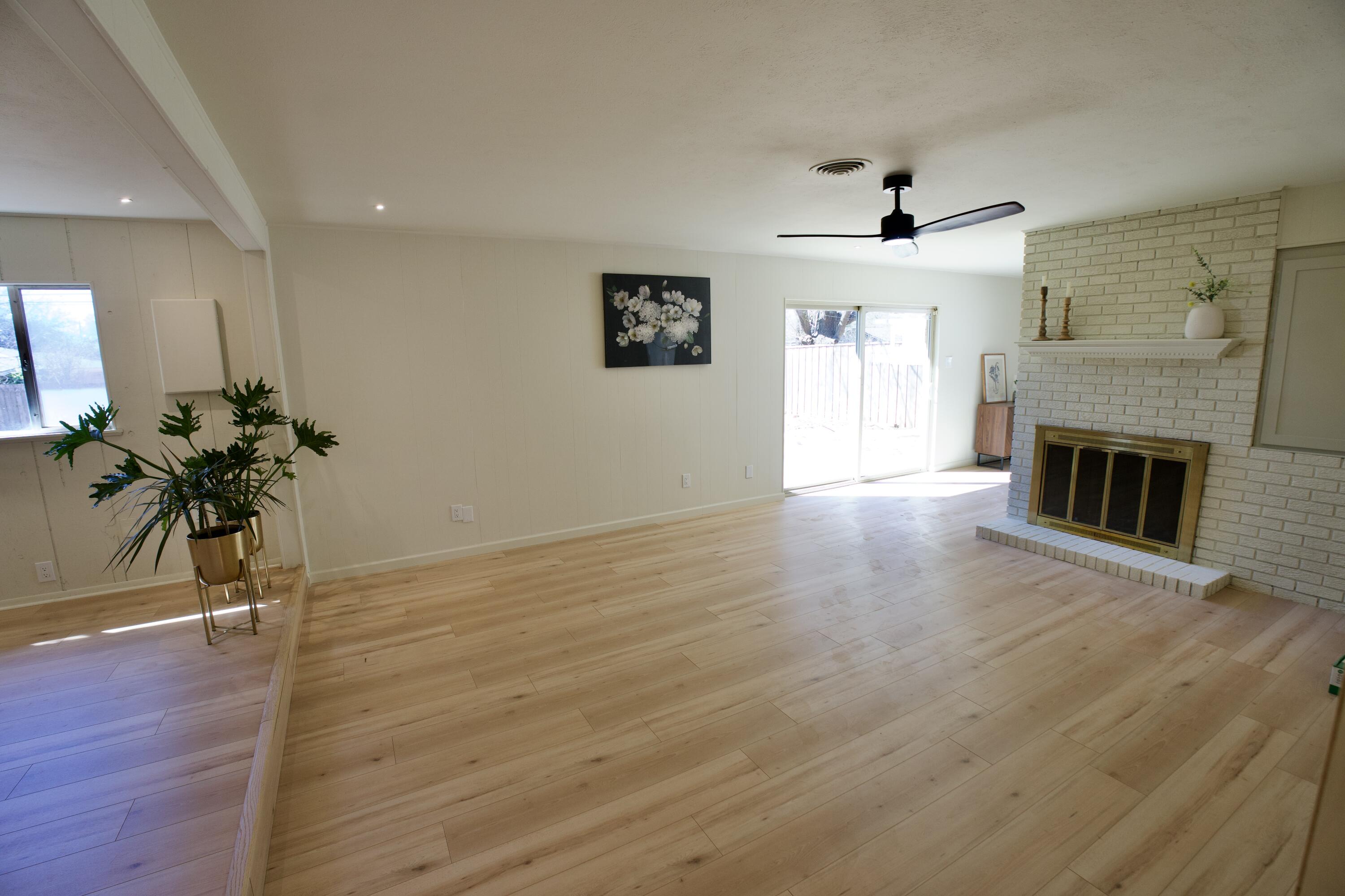 3625 59th Street Lubbock, TX 79413 - Photo 11 of 41 a view of an empty room with wooden floor and a fireplace