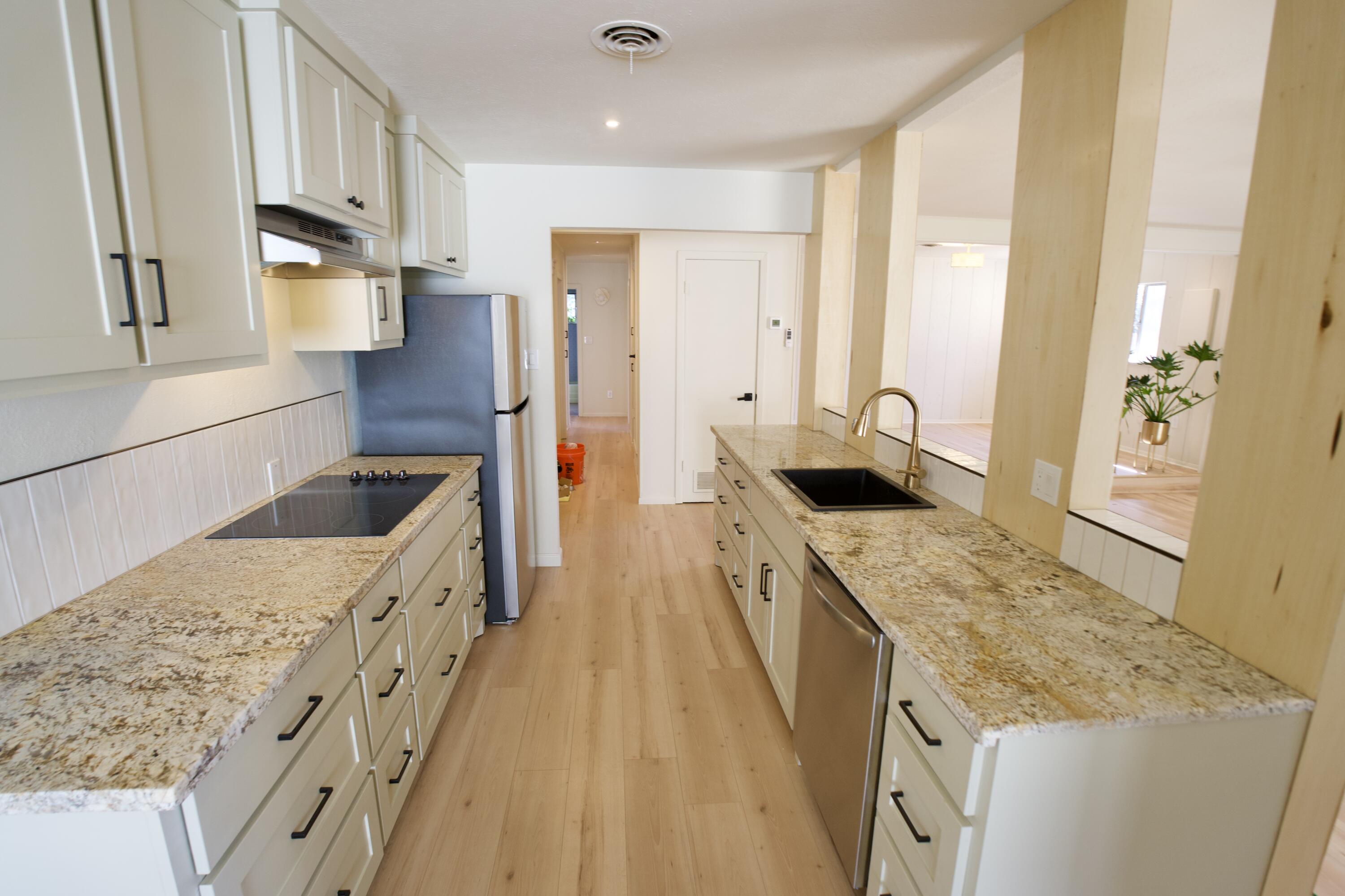 3625 59th Street Lubbock, TX 79413 - Photo 33 of 41 a large kitchen with stainless steel appliances granite countertop a lot of counter space and wooden floors