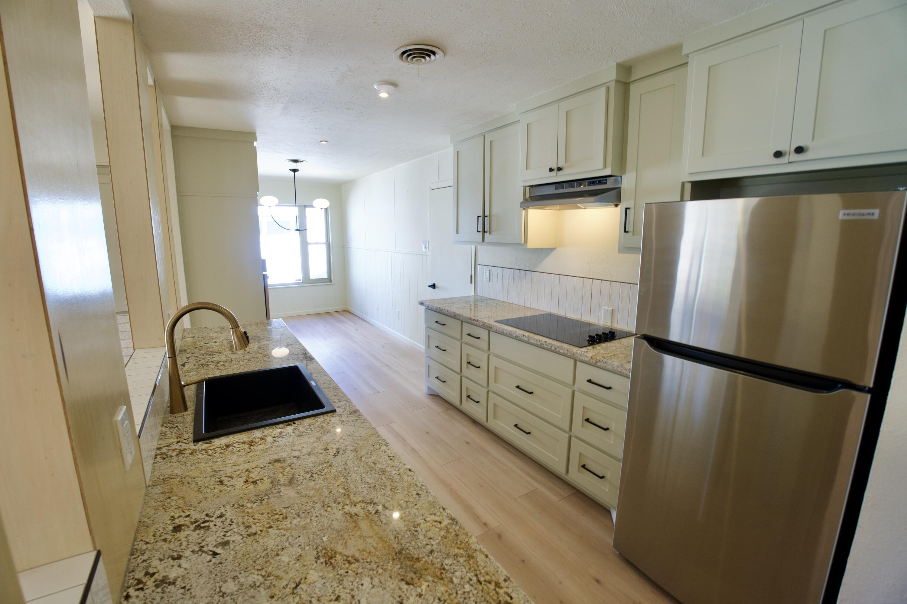 3625 59th Street Lubbock, TX 79413 - Photo 34 of 41 a kitchen with granite countertop a refrigerator a sink a stove a microwave and cabinets