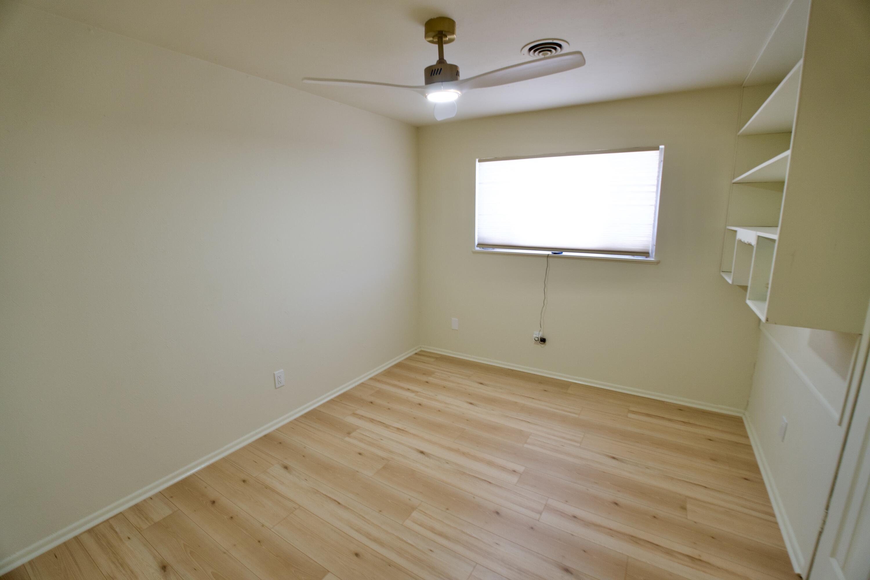 3625 59th Street Lubbock, TX 79413 - Photo 36 of 41 a view of an empty room with wooden floor and a window