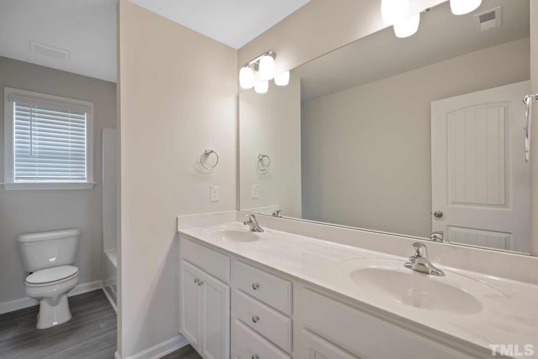 181 Karlov Road Garner, NC 27529 - Photo 16 of 21 a bathroom with a toilet a sink and mirror