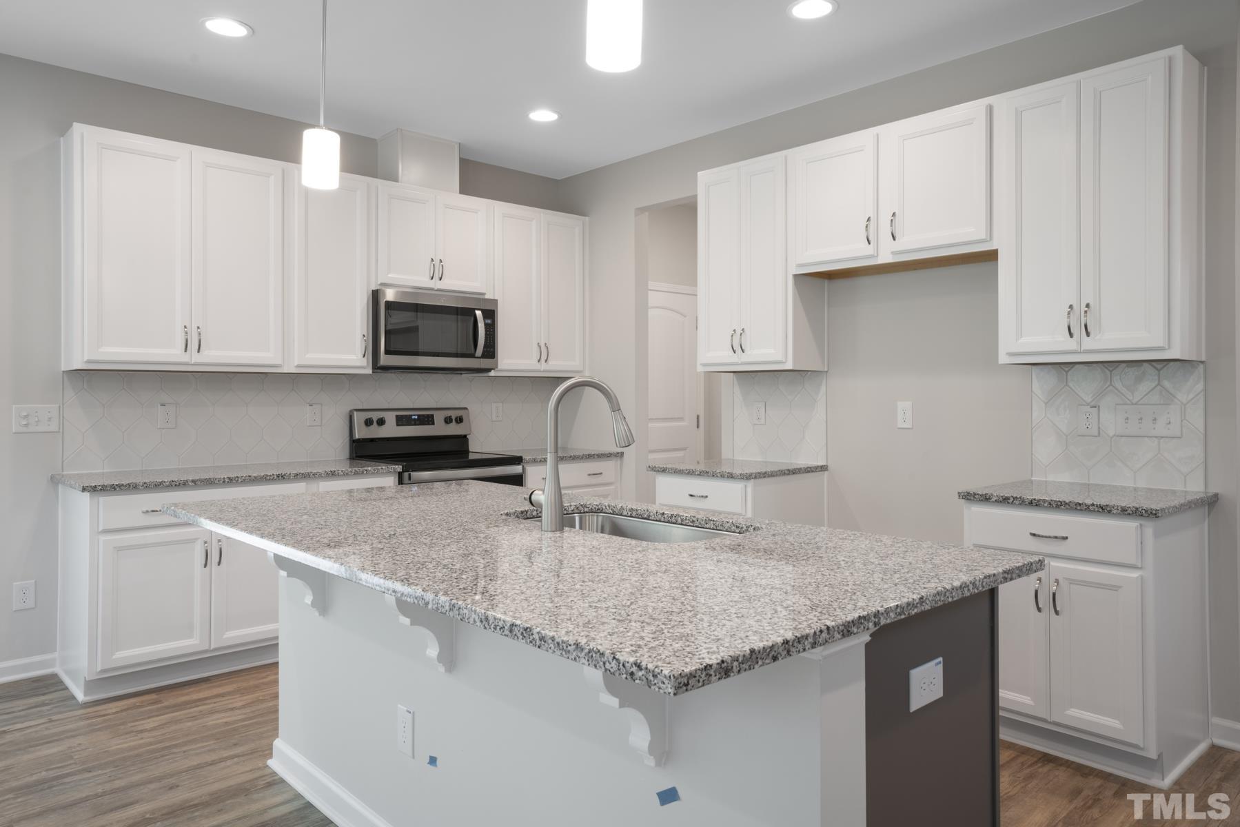 181 Karlov Road Garner, NC 27529 - Photo 5 of 21 a kitchen with granite countertop a sink a stove and cabinets