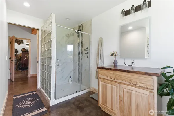 a spacious bathroom with a shower a sink and a mirror