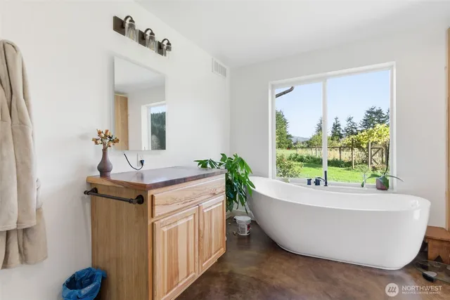 a bathroom with a bathtub and mirror