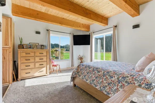 a living room with a bed furniture and a large window