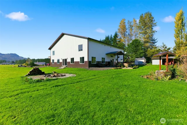 a view of a house with backyard and trees