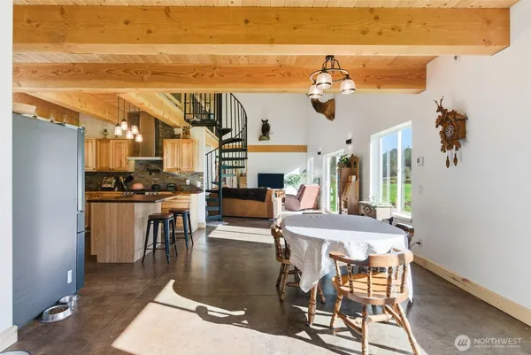 a dining room with wooden floor a chandelier a wooden table and chairs
