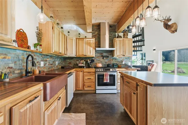 a kitchen with stainless steel appliances granite countertop a stove a sink dishwasher and cabinets with wooden floor