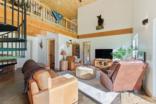 a living room with furniture a flat screen tv and a large window