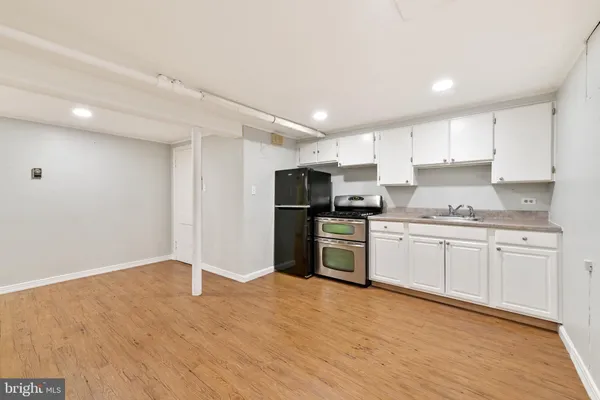 a kitchen with granite countertop a refrigerator stove top oven and cabinets