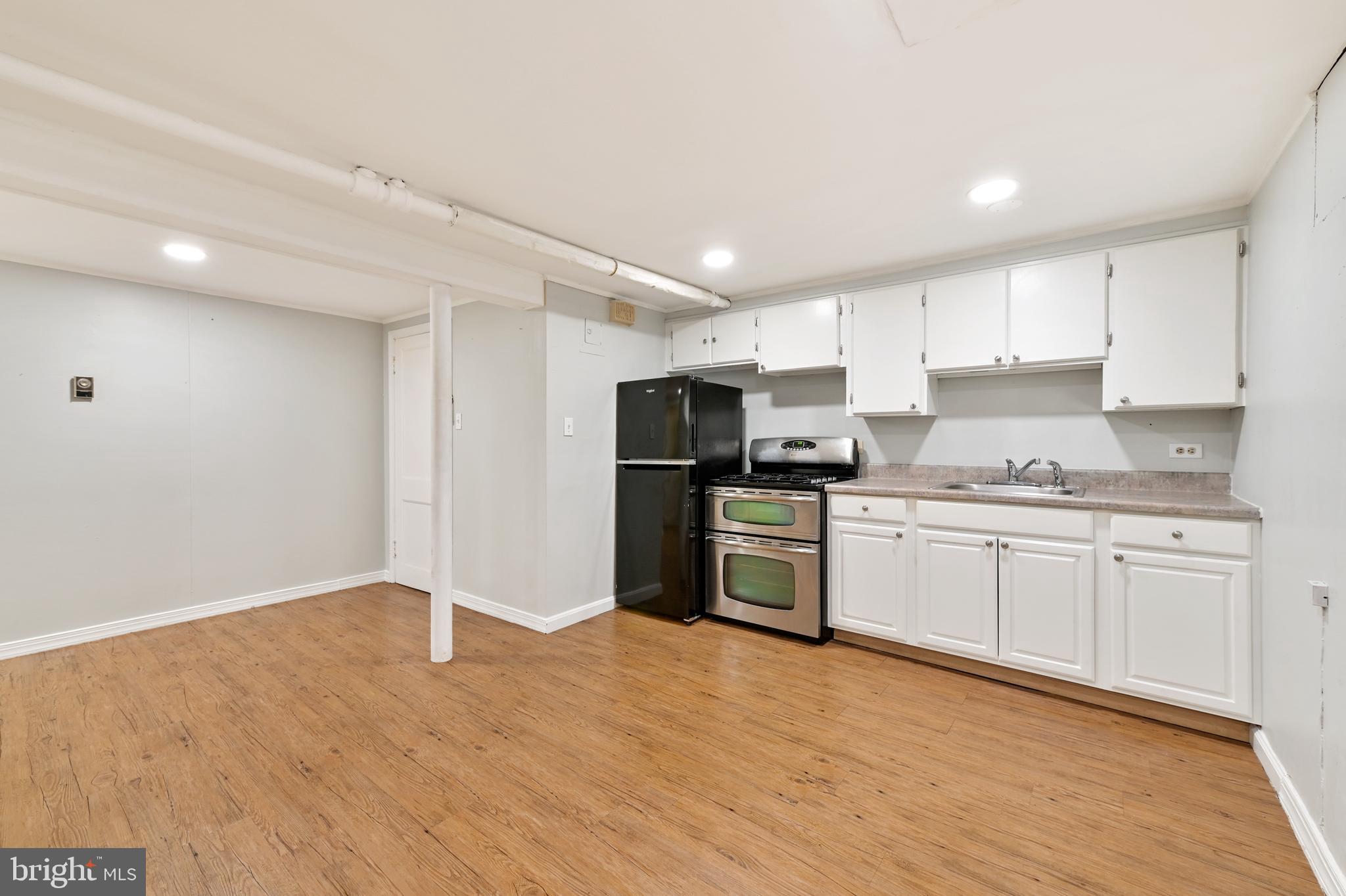 101 East 33rd Street, Unit B Baltimore, MD 21218 - Photo 5 of 7 a kitchen with granite countertop a refrigerator stove top oven and cabinets