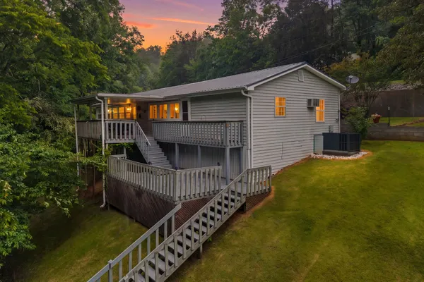 a front view of house along with deck and outdoor seating
