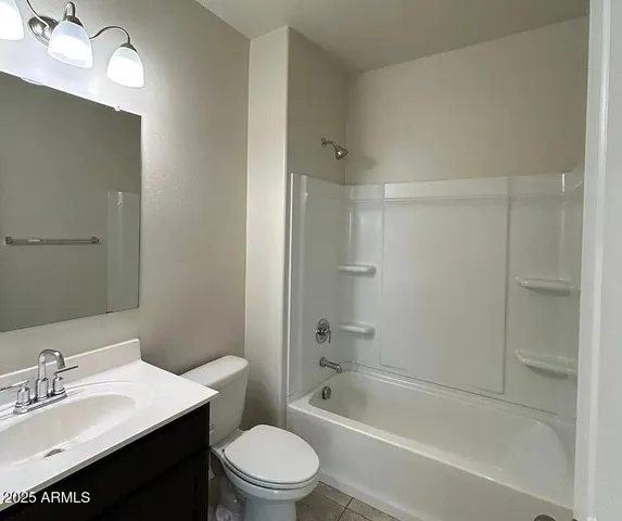a bathroom with a bathtub shower sink mirror vanity and toilet