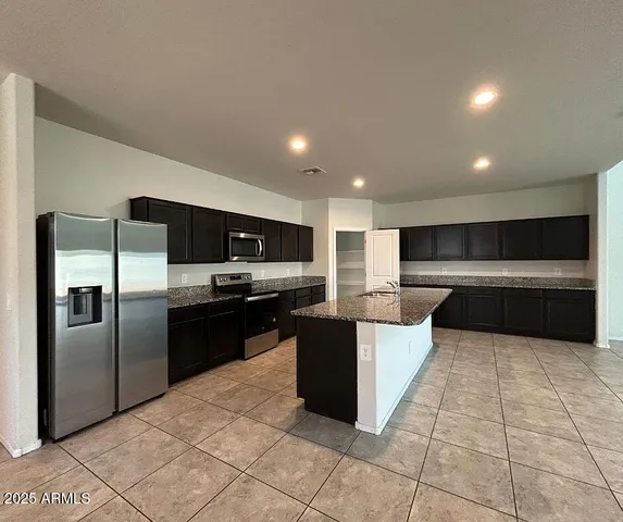a large kitchen with a large counter top and stainless steel appliances