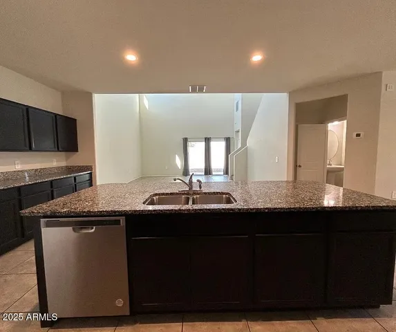 a kitchen with kitchen island granite countertop a sink and a stove