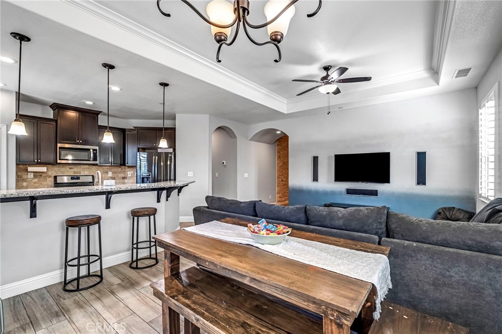 294 Double Tree Court Madera, CA 93637 - Photo 12 of 40 a living room with stainless steel appliances kitchen island granite countertop furniture and a flat screen tv