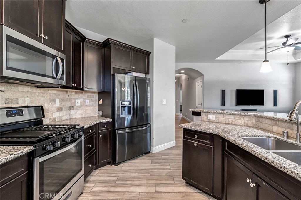 294 Double Tree Court Madera, CA 93637 - Photo 16 of 40 a kitchen with stainless steel appliances granite countertop a stove microwave and refrigerator