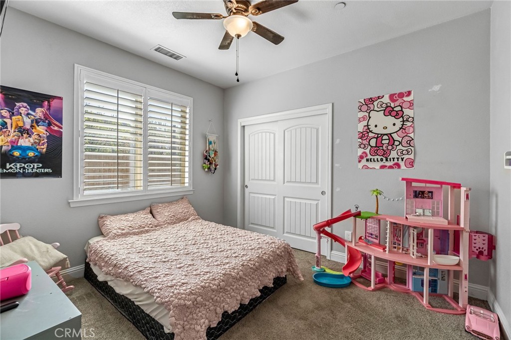 294 Double Tree Court Madera, CA 93637 - Photo 20 of 40 a bedroom with a bed and a chandelier