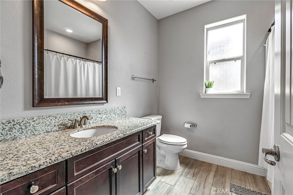 294 Double Tree Court Madera, CA 93637 - Photo 22 of 40 a bathroom with a granite countertop sink a toilet and a mirror