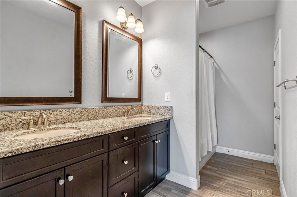 294 Double Tree Court Madera, CA 93637 - Photo 26 of 40 a bathroom with a granite countertop sink and a mirror