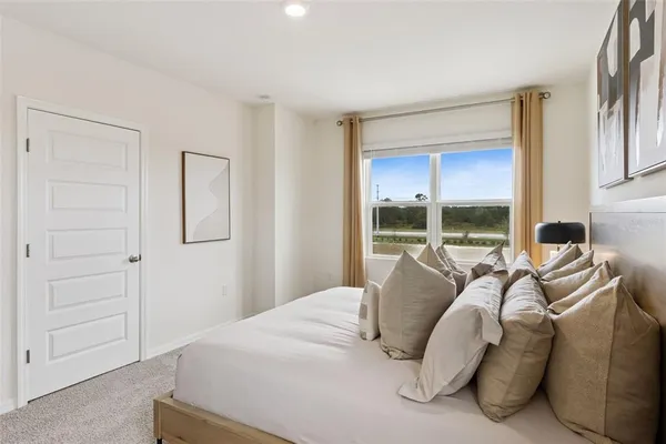a bedroom with a bed and a large window