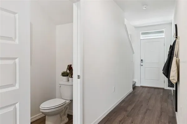 a bathroom with a granite countertop toilet and a wooden floor