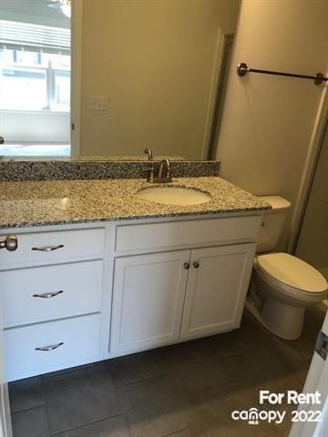 8151 Sheffield Dr. Terrell, NC 28682 - Photo 12 of 15 a bathroom with a granite countertop sink a toilet and a mirror