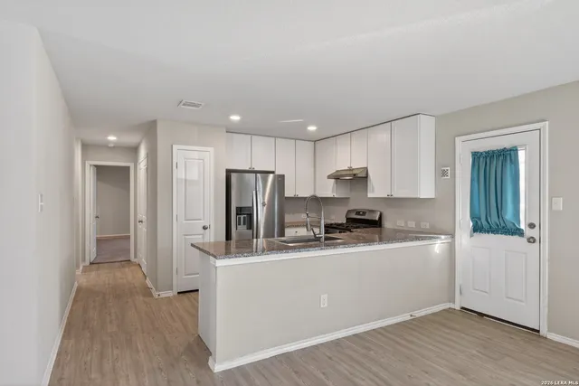 a kitchen with stainless steel appliances a refrigerator sink and microwave
