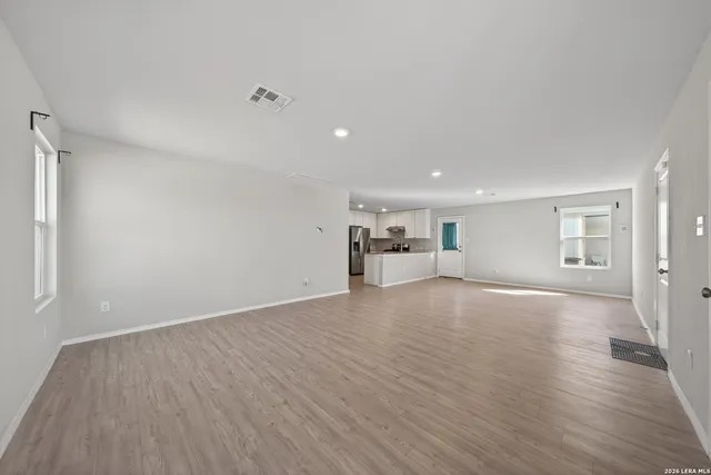 a view of empty room with wooden floor