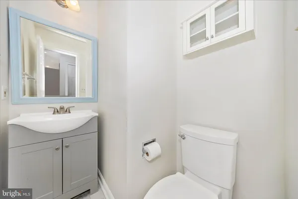 a bathroom with a granite countertop sink mirror and a toilet
