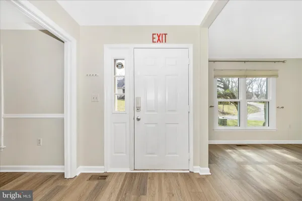 an entryway to room with wooden floor and windows