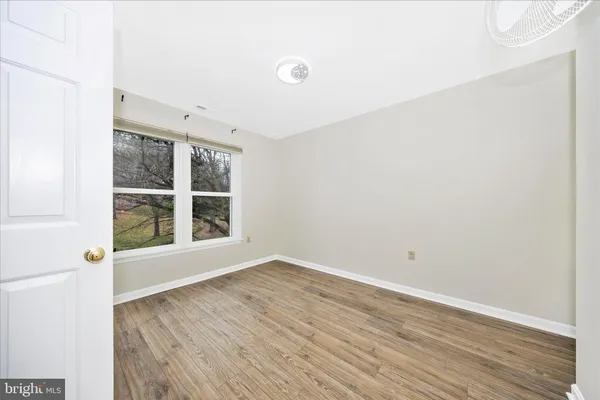 a view of an empty room with wooden floor